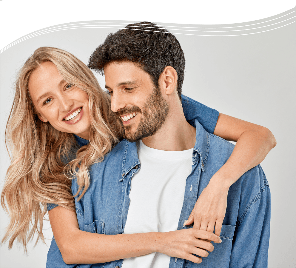 A woman with beautiful hair hugging a man while smiling.